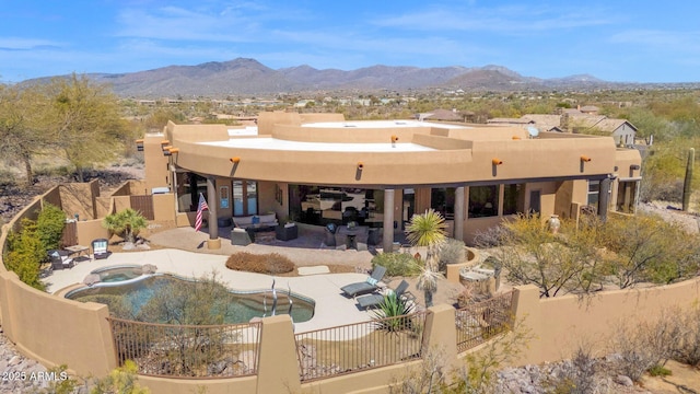 exterior space featuring a patio area, a mountain view, a fenced backyard, and an outdoor hangout area