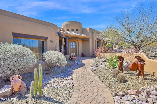 doorway to property featuring stucco siding