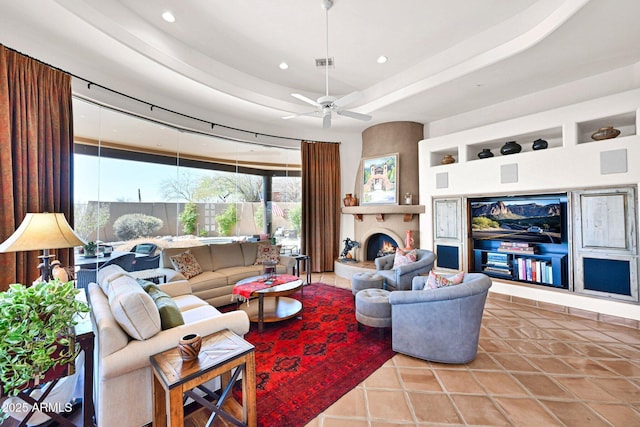 tiled living room featuring a tray ceiling, recessed lighting, a fireplace, and built in features