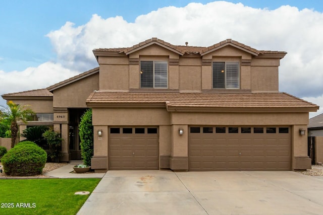 view of front of house featuring stucco siding, driveway, an attached garage, and a tile roof