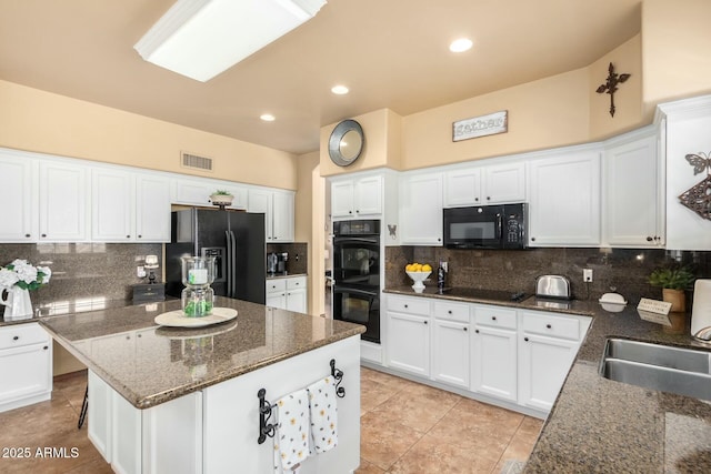 kitchen featuring visible vents, tasteful backsplash, black appliances, and white cabinets