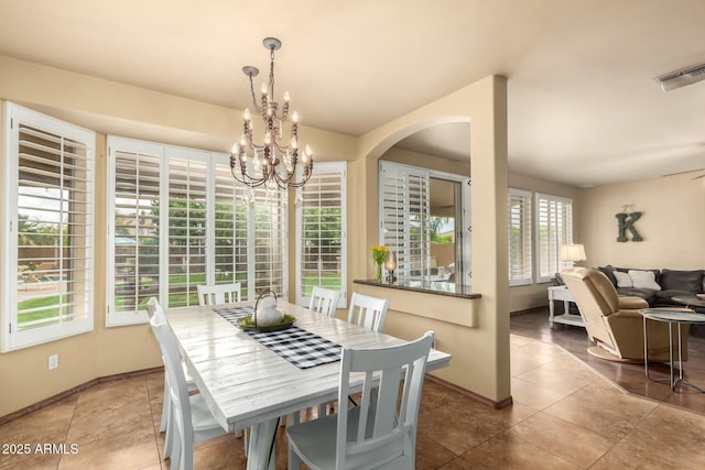 tiled dining space featuring visible vents, baseboards, and an inviting chandelier