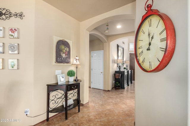 corridor featuring tile patterned flooring and arched walkways