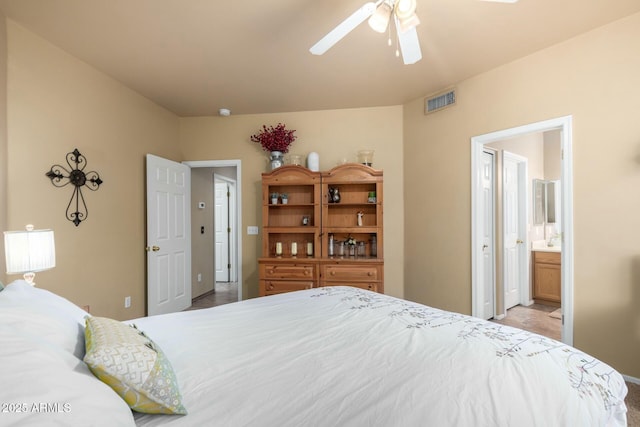 bedroom featuring a ceiling fan, visible vents, and ensuite bathroom