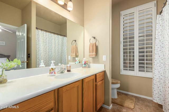 bathroom with baseboards, toilet, and vanity