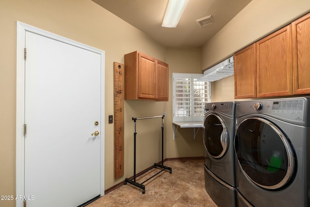 laundry area featuring cabinet space, washing machine and dryer, visible vents, and baseboards