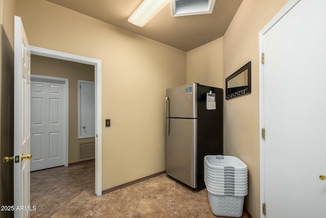 kitchen featuring visible vents, freestanding refrigerator, and baseboards