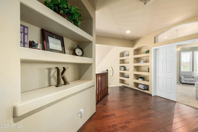 hallway with built in features, dark wood finished floors, and recessed lighting