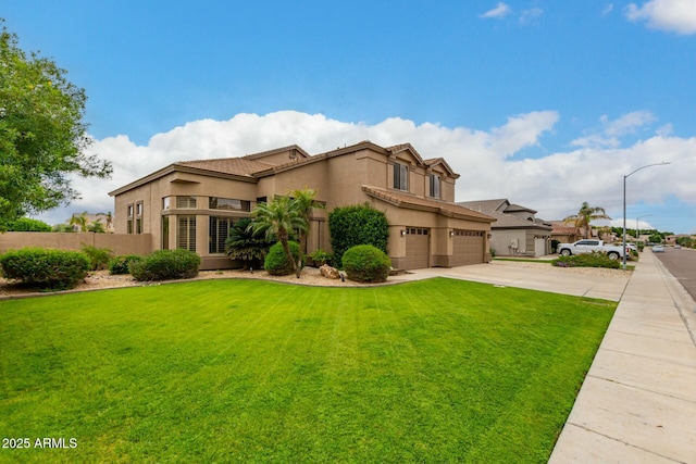 view of front facade with a front yard, fence, an attached garage, stucco siding, and concrete driveway