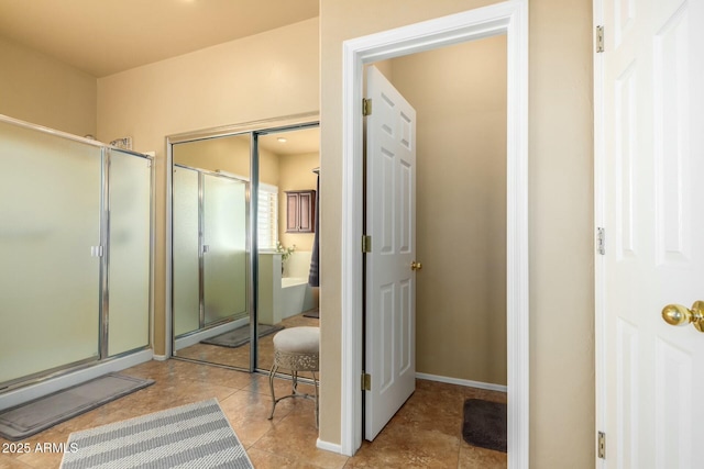 bathroom with baseboards and a shower with door