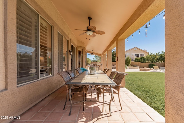 view of patio with outdoor dining space, a ceiling fan, and fence