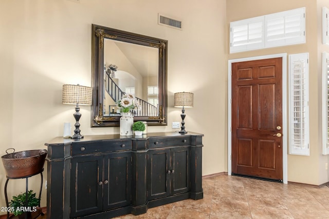 foyer entrance with visible vents and baseboards