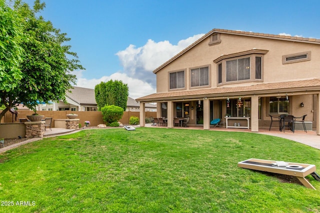 back of property with a patio area, fence, a lawn, and stucco siding