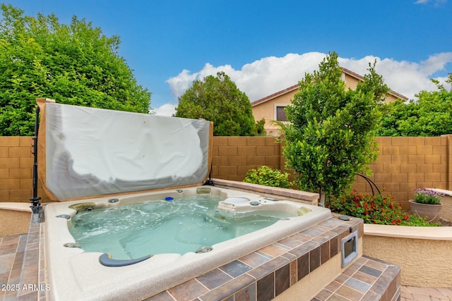 view of pool featuring a covered hot tub and fence