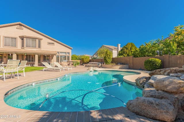 view of swimming pool featuring a patio, a fenced backyard, and a fenced in pool