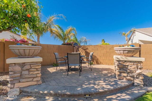 view of patio with outdoor dining space and fence