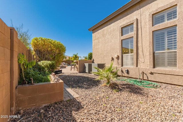 view of home's exterior featuring stucco siding, cooling unit, a fenced backyard, and a patio area