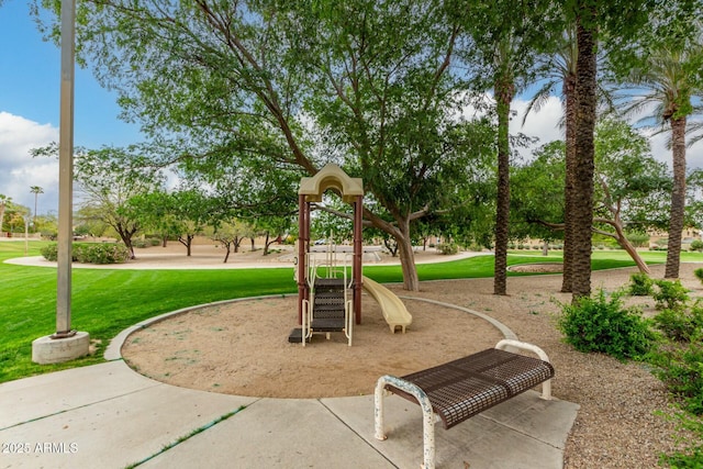 view of home's community featuring playground community and a lawn