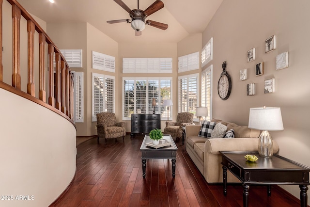 living room featuring a high ceiling, a ceiling fan, and dark wood-style flooring