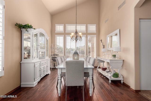 dining space featuring a notable chandelier, visible vents, dark wood-style flooring, and high vaulted ceiling