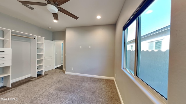 unfurnished bedroom with dark carpet and ceiling fan