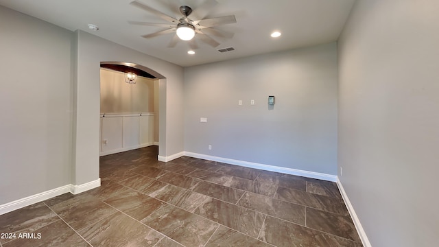 unfurnished room featuring dark tile flooring and ceiling fan