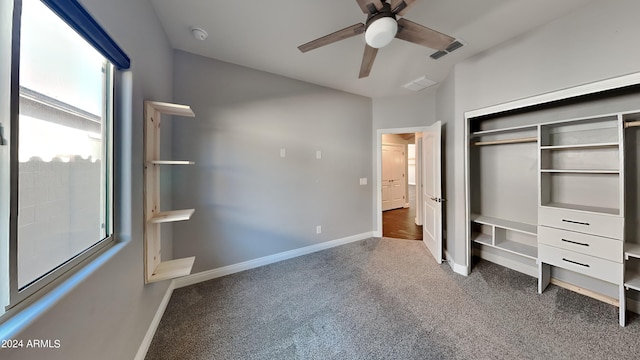 unfurnished bedroom with a closet, ceiling fan, and dark colored carpet