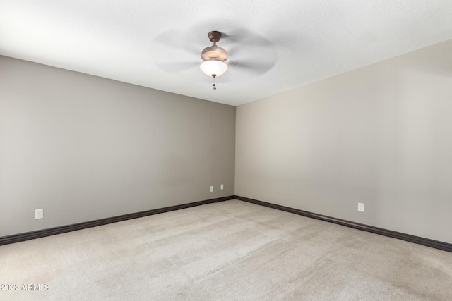 spare room with ceiling fan and light colored carpet