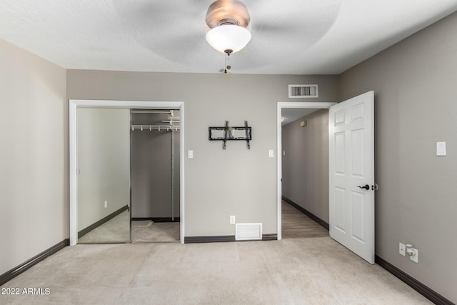 unfurnished bedroom with ceiling fan, a closet, and light colored carpet