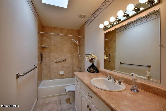 full bathroom featuring a skylight, tile patterned floors, toilet, vanity, and tiled shower / bath