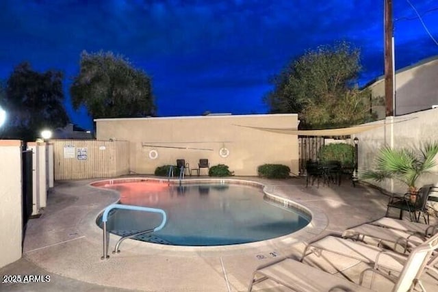 pool at twilight with a patio