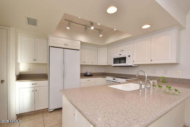 kitchen with kitchen peninsula, track lighting, white appliances, sink, and white cabinets