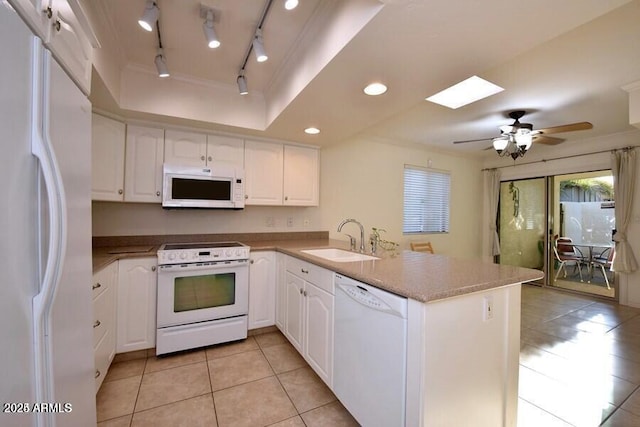 kitchen with kitchen peninsula, white appliances, ceiling fan, sink, and white cabinetry