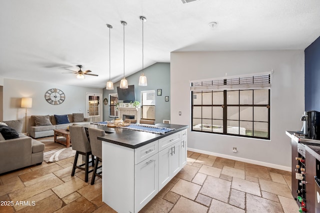 kitchen with white cabinets, a wealth of natural light, hanging light fixtures, and ceiling fan