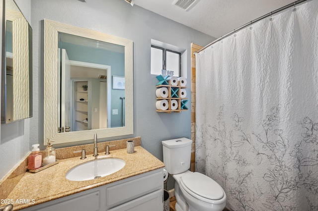 bathroom featuring vanity, toilet, and a textured ceiling