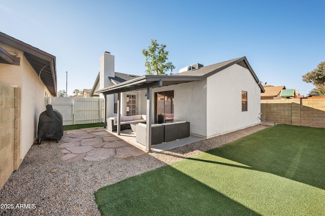 rear view of property with a lawn, a patio area, and an outdoor living space