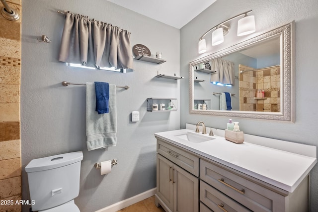 bathroom featuring vanity, toilet, and tiled shower