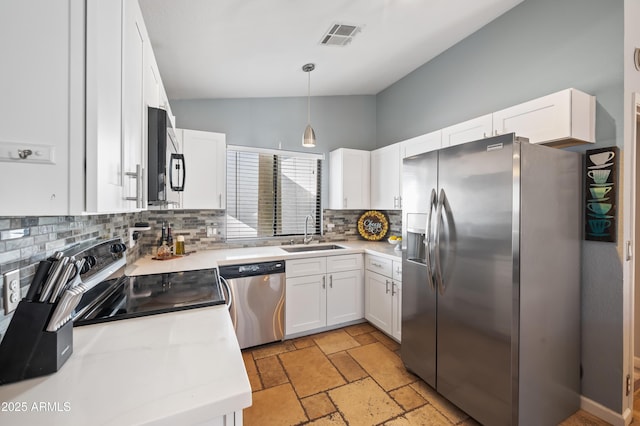 kitchen featuring appliances with stainless steel finishes, sink, pendant lighting, white cabinets, and lofted ceiling