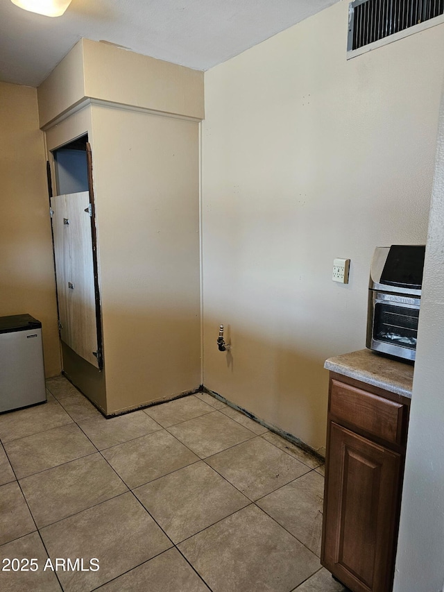 kitchen with stainless steel refrigerator and light tile patterned floors