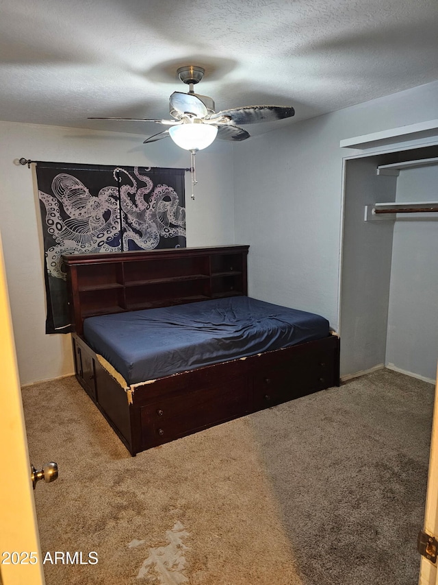 carpeted bedroom with a textured ceiling, a closet, and ceiling fan