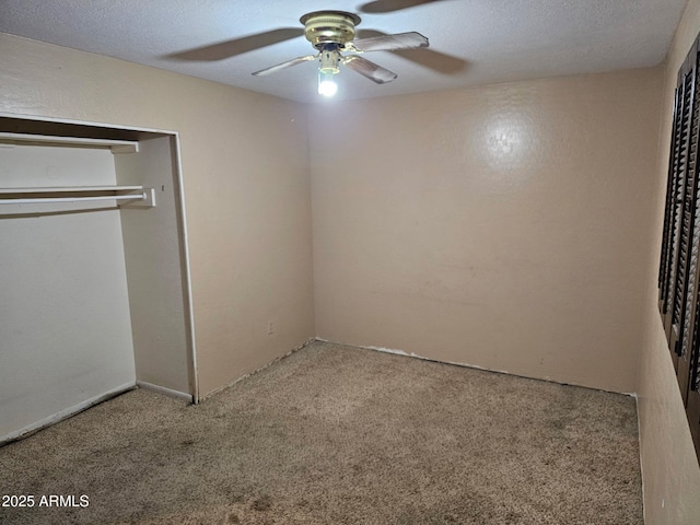 unfurnished bedroom featuring ceiling fan, a textured ceiling, light carpet, and a closet