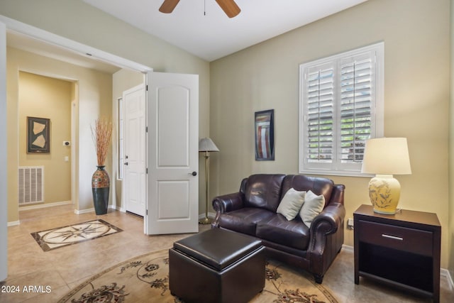 living room with light tile patterned floors, ceiling fan, visible vents, and baseboards