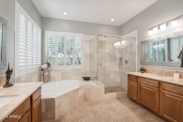 bathroom featuring tile patterned floors, vanity, and shower with separate bathtub