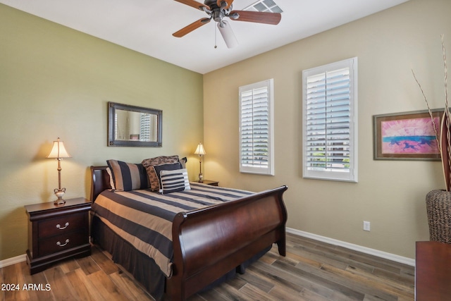 bedroom with dark wood-style floors, visible vents, and baseboards