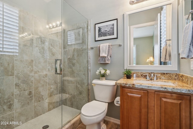 bathroom featuring vanity, a shower stall, and toilet