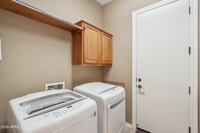 washroom featuring washing machine and dryer and cabinet space