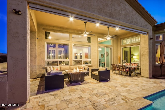 view of patio / terrace featuring outdoor dining area, a ceiling fan, and an outdoor living space with a fire pit