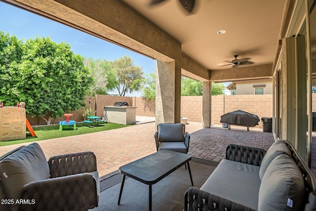 view of patio / terrace featuring ceiling fan, an outdoor kitchen, a grill, and a playground