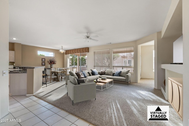 living room with ceiling fan with notable chandelier and light tile patterned floors