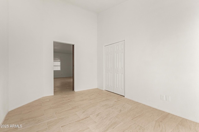 unfurnished room featuring a high ceiling